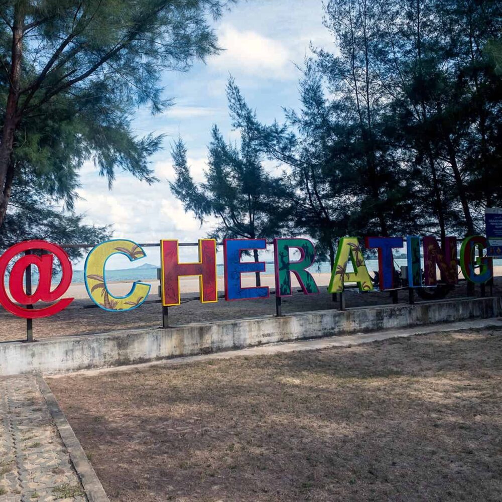 Cherating Beach landmark sign with colourful letters and South China Sea in the background