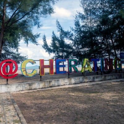 Cherating Beach landmark sign with colourful letters and South China Sea in the background