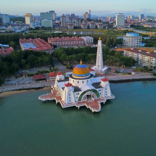 Straits Mosque Malacca – Aerial View of Masjid Selat Melaka Aerial view of the Straits Mosque (Masjid Selat Melaka) built over the water in Malacca, Malaysia, with the city skyline in the background.