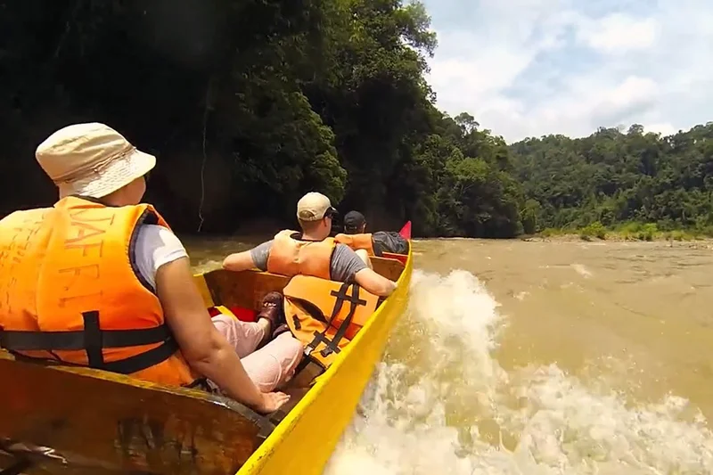 Tourists riding a longboat through rapids during a river cruise in Taman Negara