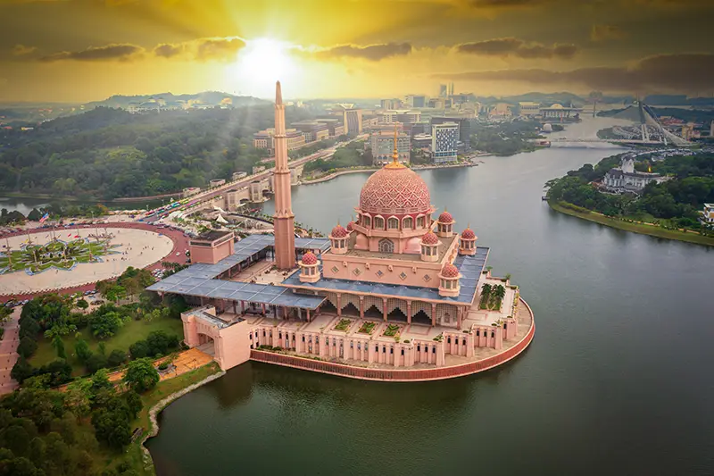 Aerial view of Putra Mosque in Putrajaya at sunrise with cityscape in the background
