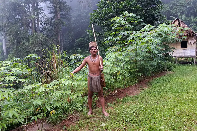 Senoi tribesman in traditional attire holding a blowpipe in Cameron Highlands during a cultural stop on a day trip Kuala Lumpur to Cameron Highlands