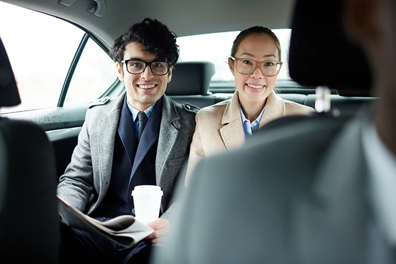 Business travelers enjoying a comfortable KLIA private transfer with an English-speaking driver
