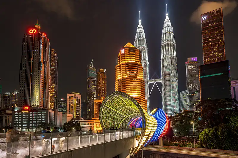 Night view of Saloma Link Bridge with Petronas Twin Towers in the background, one of Kuala Lumpur’s world-class attractions.