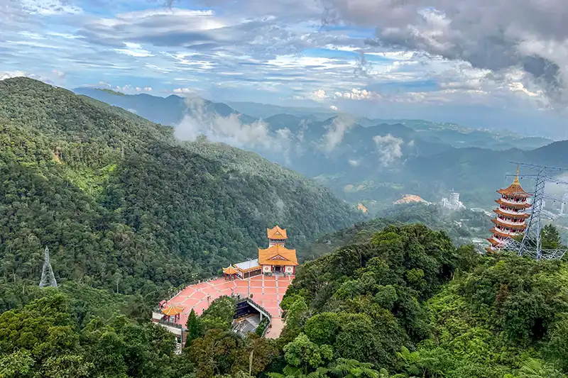 Scenic view of Chin Swee Caves Temple surrounded by misty rainforest in Genting Highlands, Malaysia.
