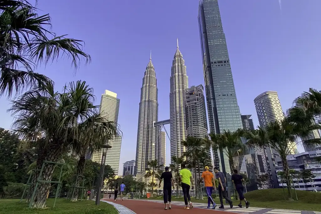 Joggers using the jogging track at KLCC Park with Petronas Twin Towers in Kuala Lumpur