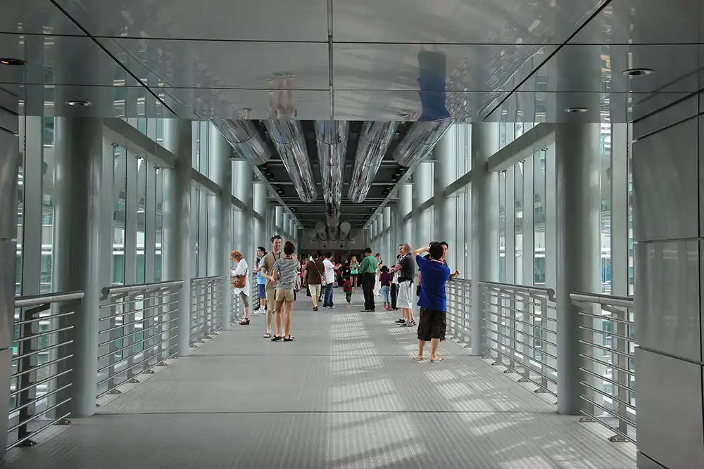 Visitors walking on the Skybridge between the Petronas Twin Towers in Kuala Lumpur