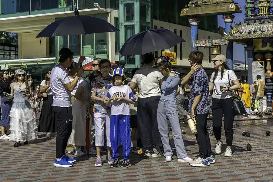 Visitors experiencing midday heat at Batu Caves temple complex