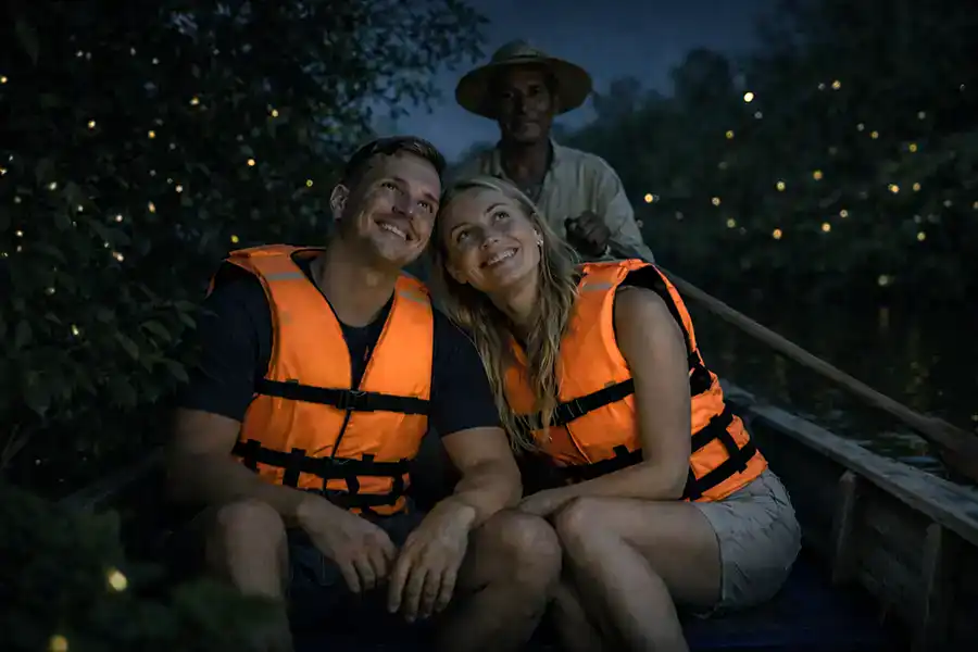 Couple watching fireflies from a manual rowing boat at Kampung Kuantan along the Selangor River