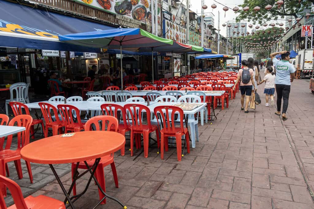 Open-air plastic tables and food stalls lining Jalan Alor street at night in Bukit Bintang — one of the most popular things to do in Bukit Bintang Kuala Lumpur for first-time visitors