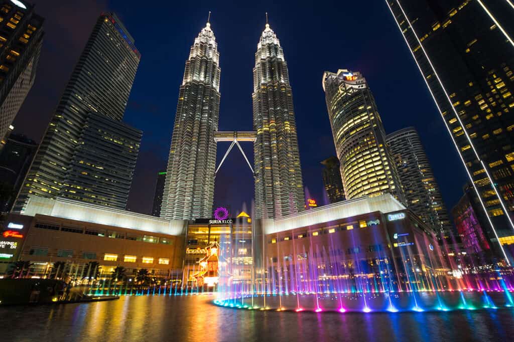 Symphony Lake fountain show at KLCC Park with Petronas Twin Towers illuminated at night, Kuala Lumpur