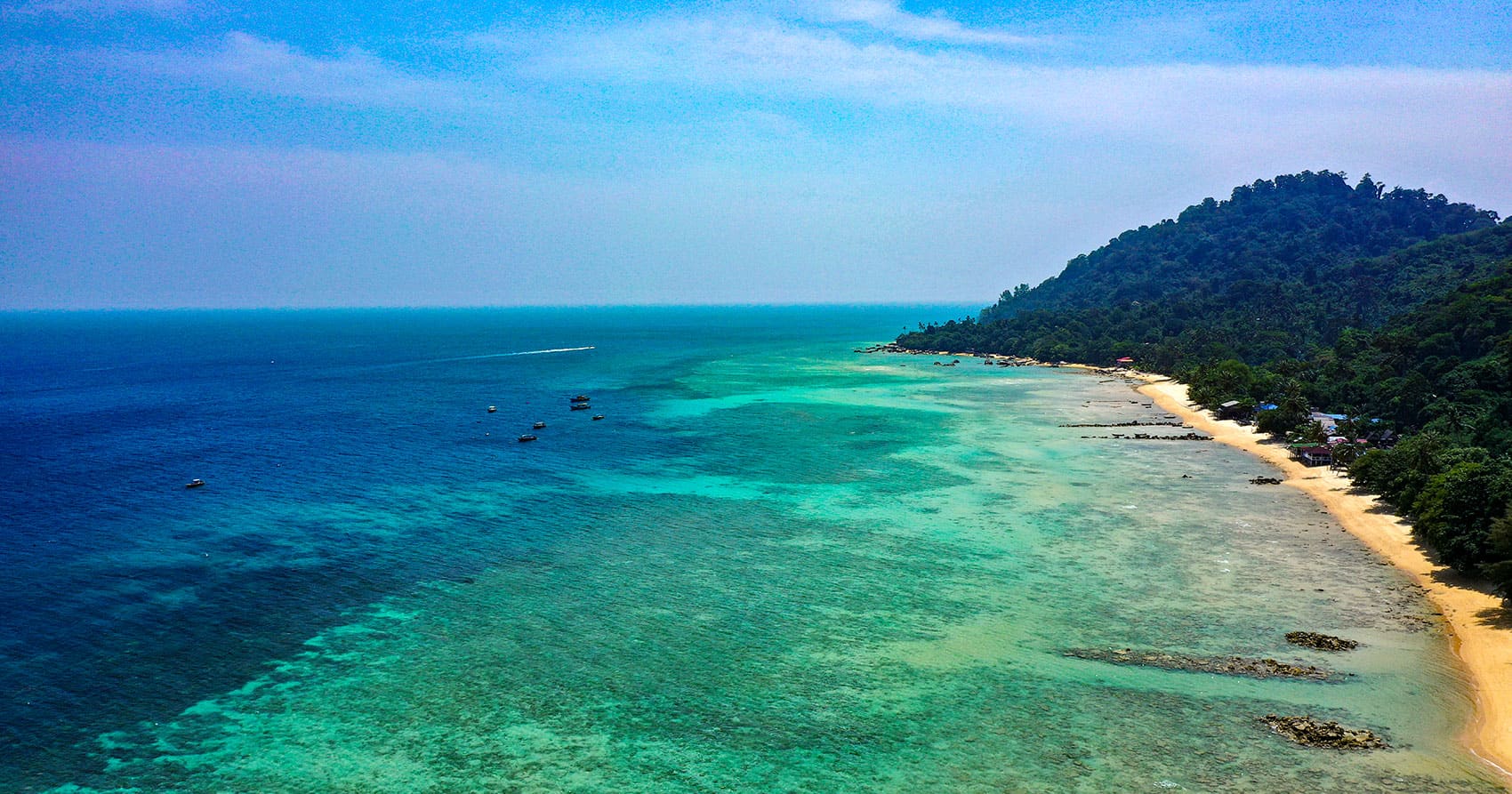 Aerial view of Tioman Island coastline showing turquoise waters and sandy beach — Kuala Lumpur to Tioman Island by private transfer