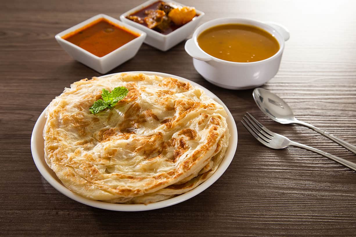 Flaky layered Roti Canai served with dhal curry and sambal — a classic Indian-Malaysian breakfast dish available at mamak stalls across Kuala Lumpur and one of the best things to eat when deciding what to do in Kuala Lumpur