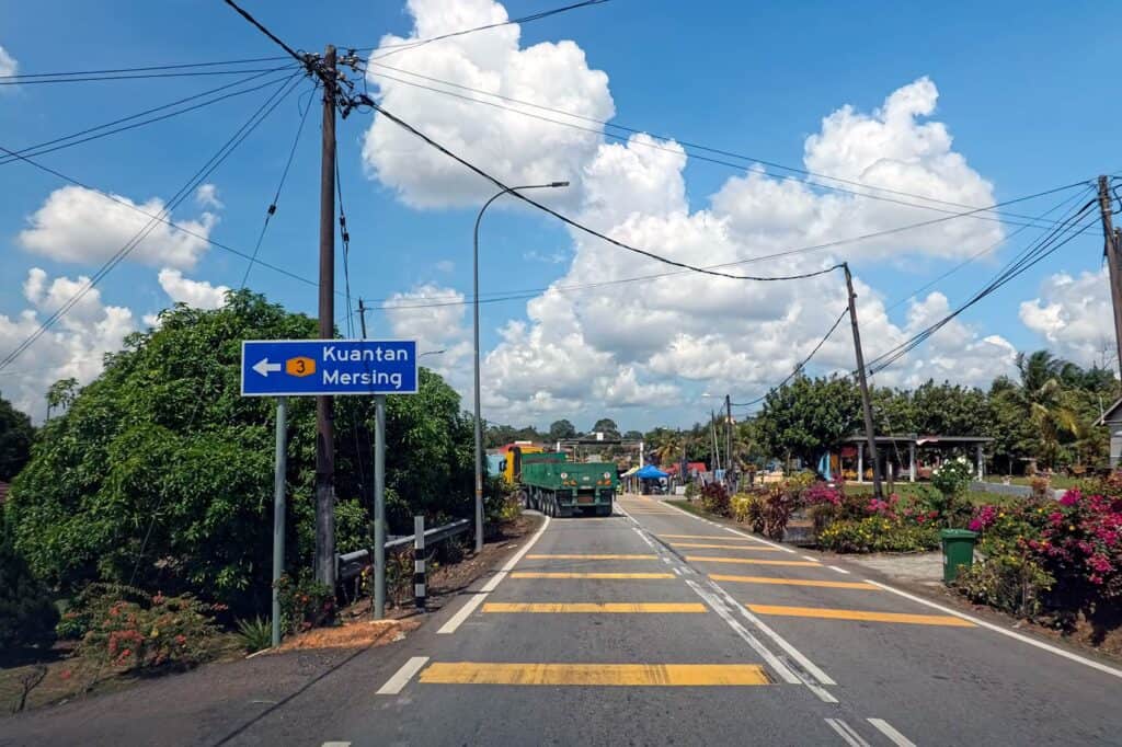 Route 3 road sign pointing toward Mersing and Kuantan — the final stretch of the drive from Kuala Lumpur to Mersing passing through a small Johor village