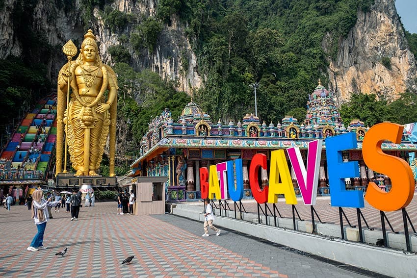 Lord Murugan statue and colourful Batu Caves sign at the entrance to the Hindu temple complex, 13km north of Kuala Lumpur