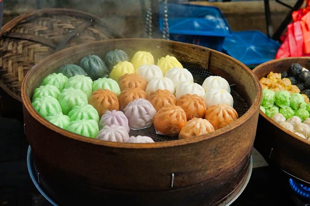 Colourful steamed bao dim sum in bamboo steamer at Ipoh Old Town street stall Malaysia