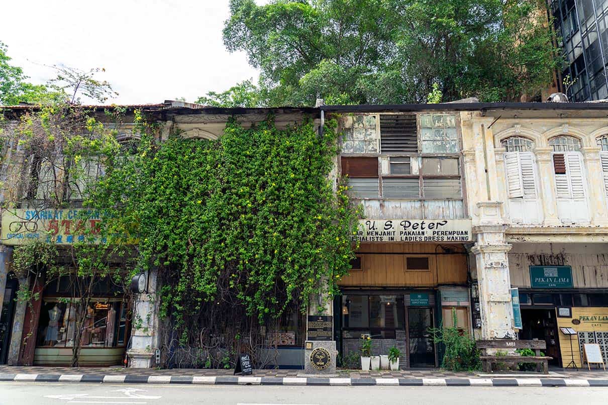 Pre-war heritage shophouses along Ipoh Old Town street Malaysia with ivy covered facade