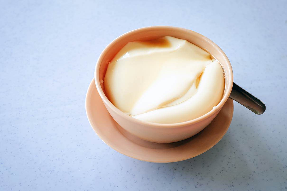 Ipoh tau foo fah silken tofu dessert in bowl with light sugar syrup Malaysia