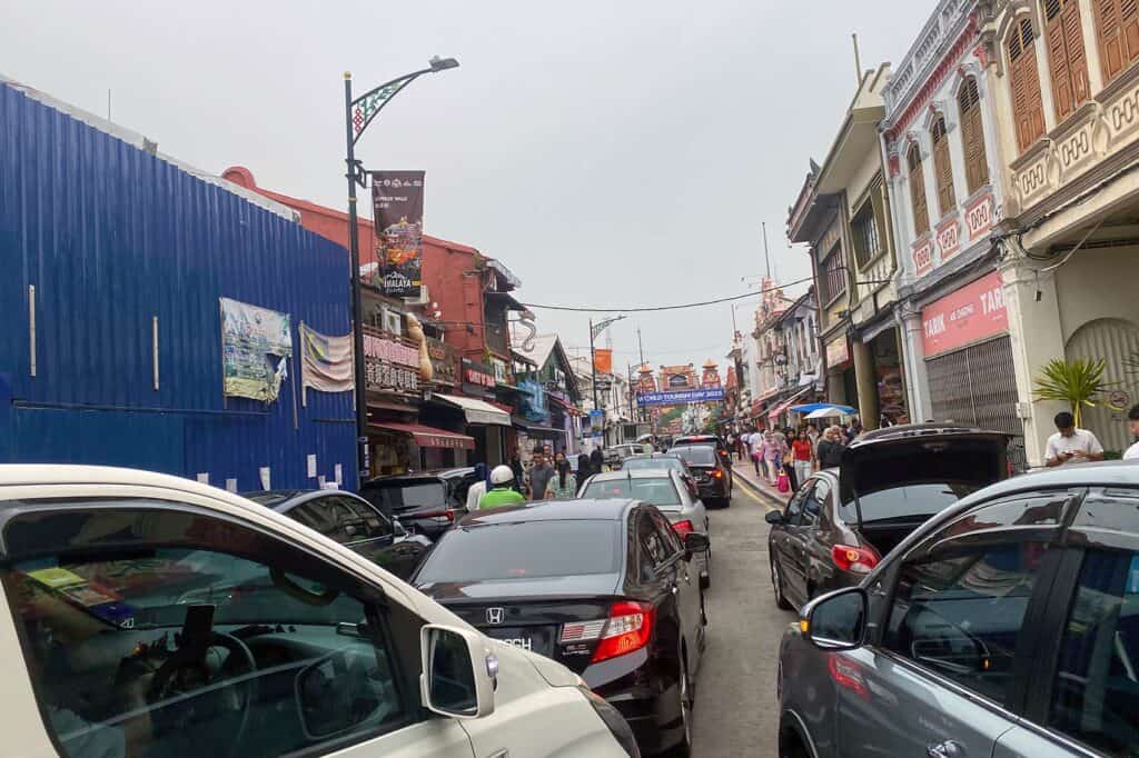 Heavy weekend traffic congestion on Jonker Street in Bandar Hilir Malacca with cars gridlocked near heritage shophouses