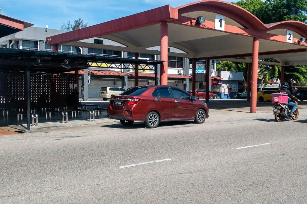 Standard sedan car waiting outside Kemaman Bus Terminal — the typical e-hailing or taxi vehicle for the 16km ride to Cherating