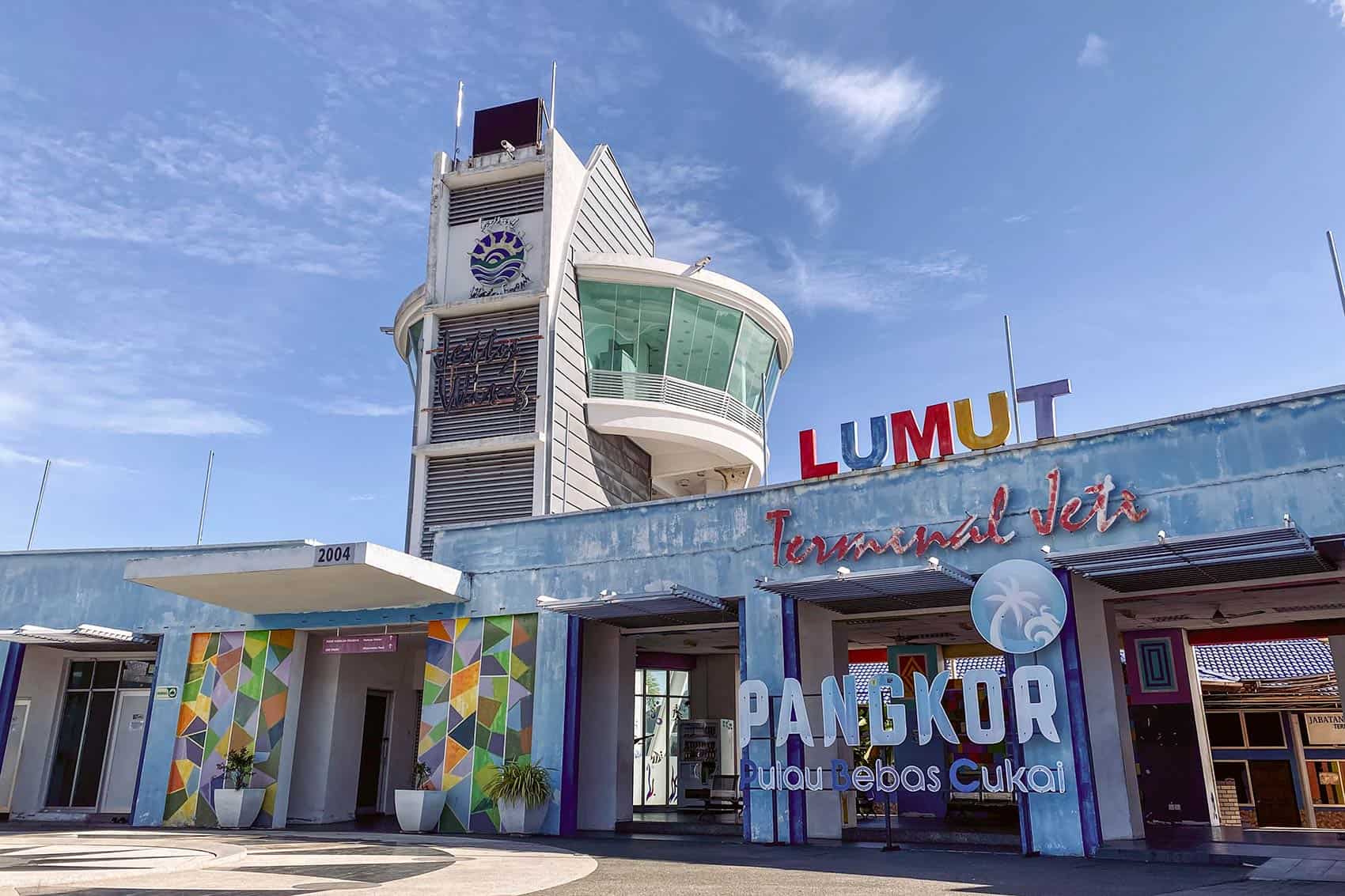 Exterior of Lumut Terminal Jeti showing the colourful Pangkor Pulau Bebas Cukai signage and terminal tower — the main departure point for the Pangkor Island ferry in Lumut, Perak