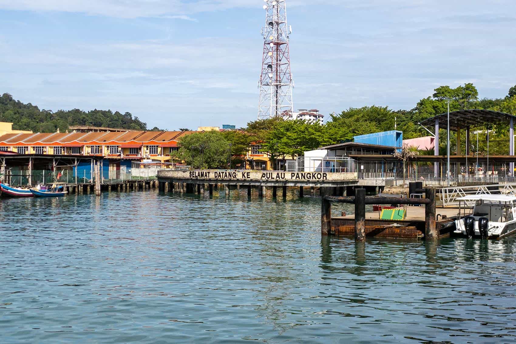 Pangkor Island Jetty arrival point viewed from the water with Selamat Datang Ke Pulau Pangkor welcome sign visible on the pier
