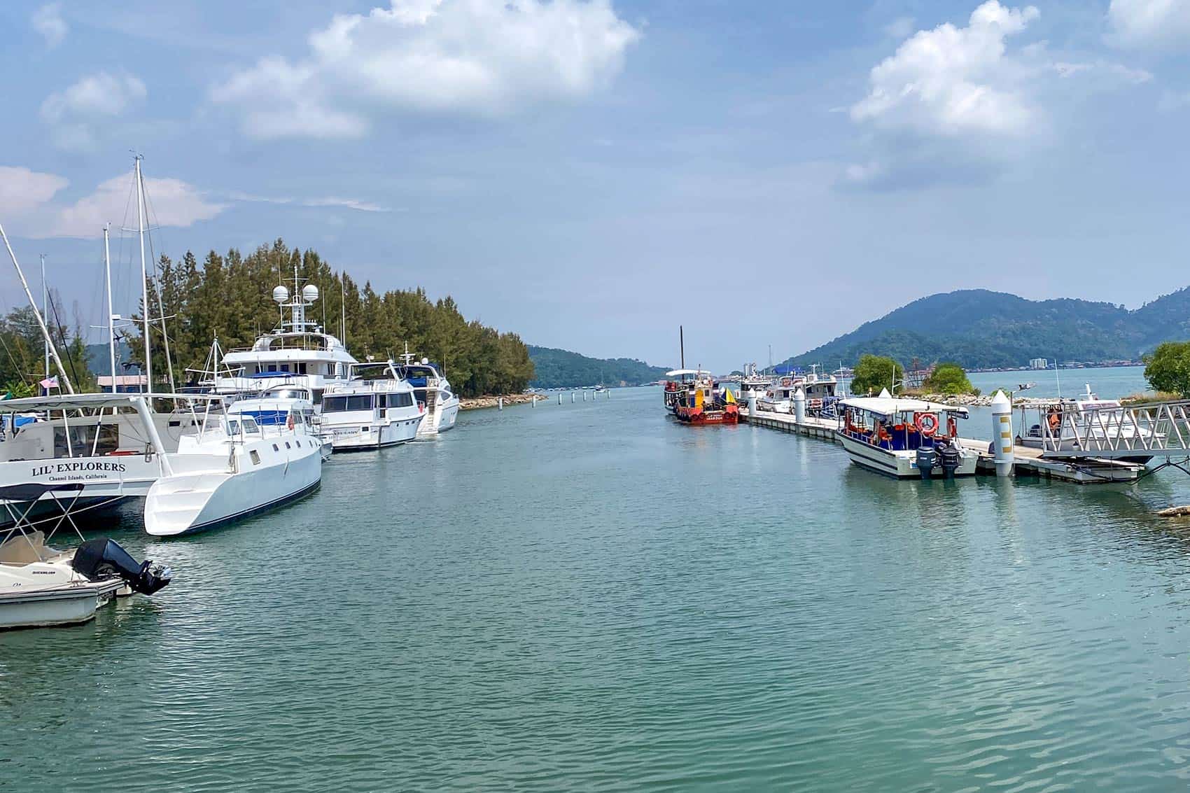 Pangkor Laut Resort private ferry jetty at Marina Island in Lumut showing luxury yachts moored on the left and the resort ferry docked on the right — a separate facility from the public Pangkor Island ferry