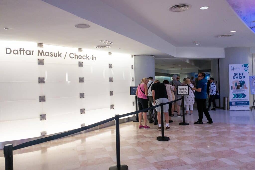 Tourists queuing at the Petronas Twin Towers Daftar Masuk Check-in area before security screening and elevator to Sky Bridge