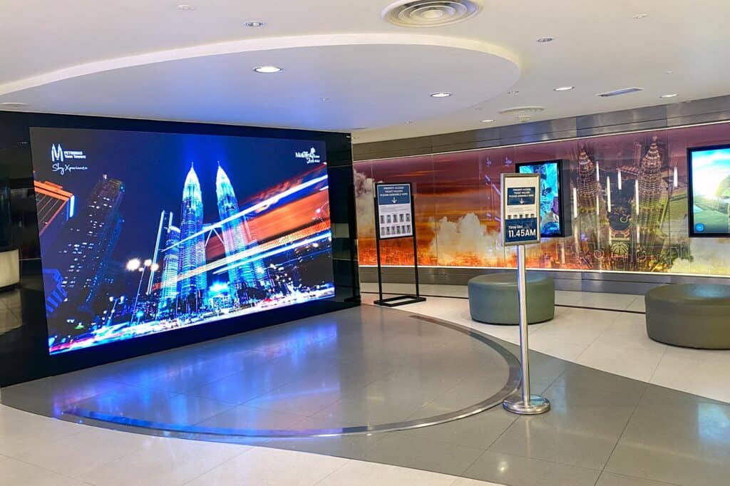 Petronas Twin Towers Priority Access ticket holder assembly area with time slot display showing 11:45am