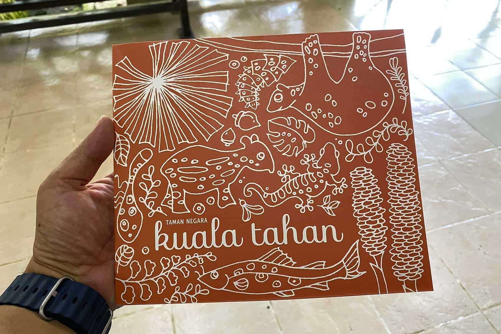 Official Taman Negara Kuala Tahan tourist map available for purchase at the PERHILITAN Department office — illustrated with local wildlife including fish, reptiles, and jungle plants