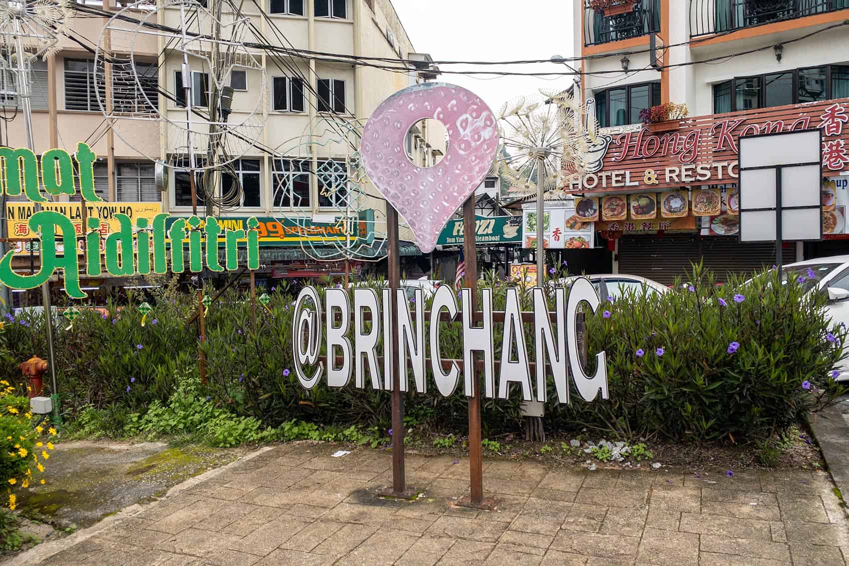 Brinchang town centre with local restaurants, hotels and shophouses behind the strawberry location sign — places to stay in Cameron Highlands for self-drive visitors