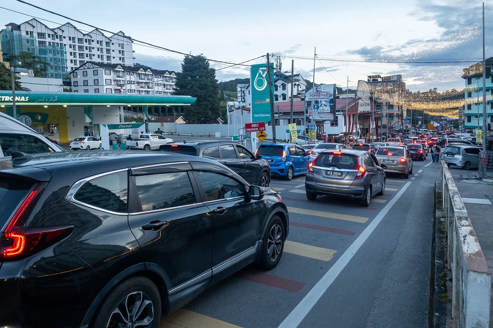 Heavy traffic congestion in Brinchang town during a peak holiday period in Cameron Highlands — self-drive tourists and tour pickups face significant delays on this road during school holidays and public holidays