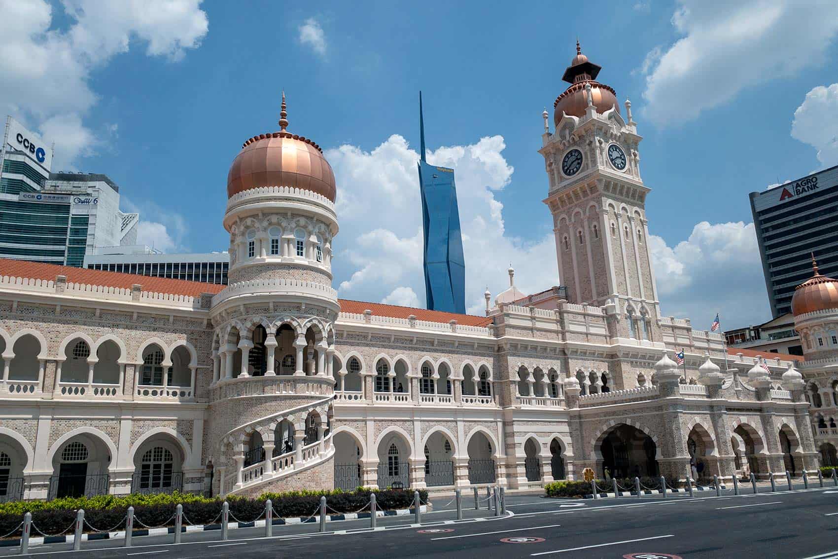 Sultan Abdul Samad Building with its copper domes and clock tower at Merdeka Square, with the Merdeka 118 Tower visible in the background — a key stop on a KL city tour