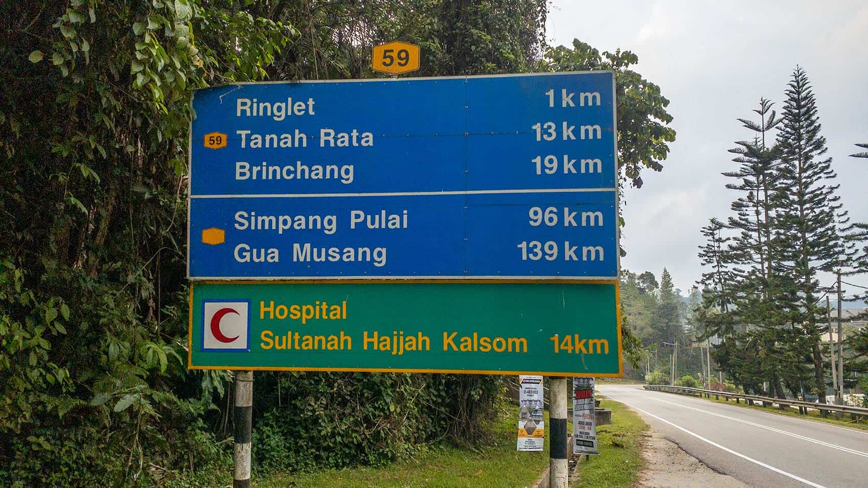 Road sign on Route 59 showing distances to Ringlet, Tanah Rata, and Brinchang — the three towns to consider when deciding where to stay in Cameron Highlands