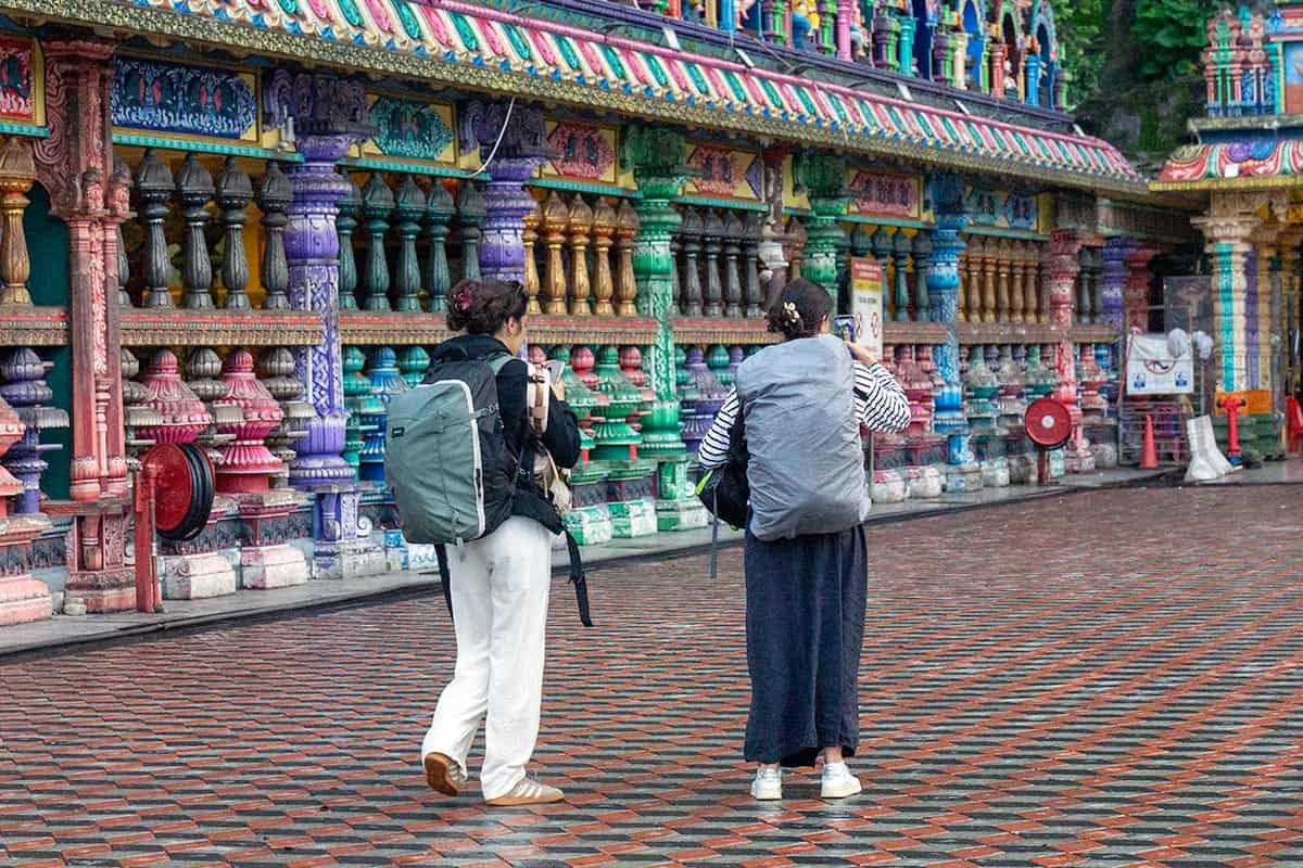 Backpackers visiting Batu Caves independently without a tour guide, exploring the temple architecture in Kuala Lumpur