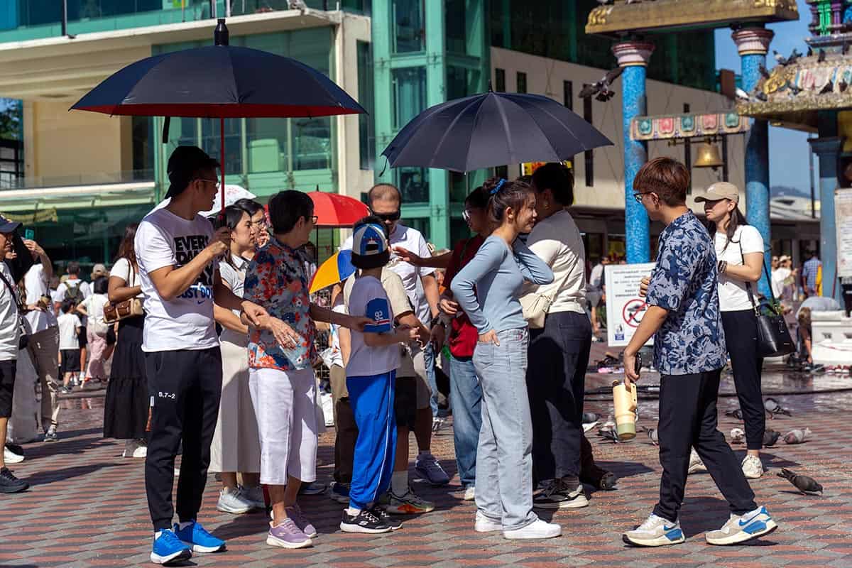 Tourists using umbrellas for sun shade at Batu Caves, near Kuala Lumpur