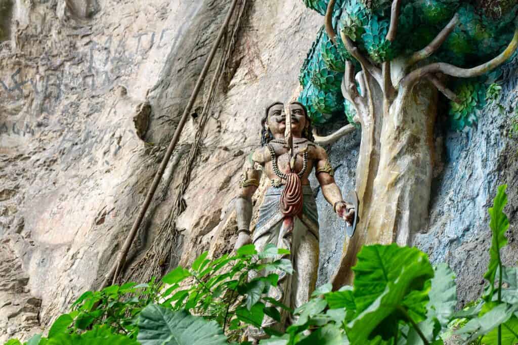 Carved statue of Surapadman, the demon defeated by Lord Murugan, on the limestone cliff face at Batu Caves